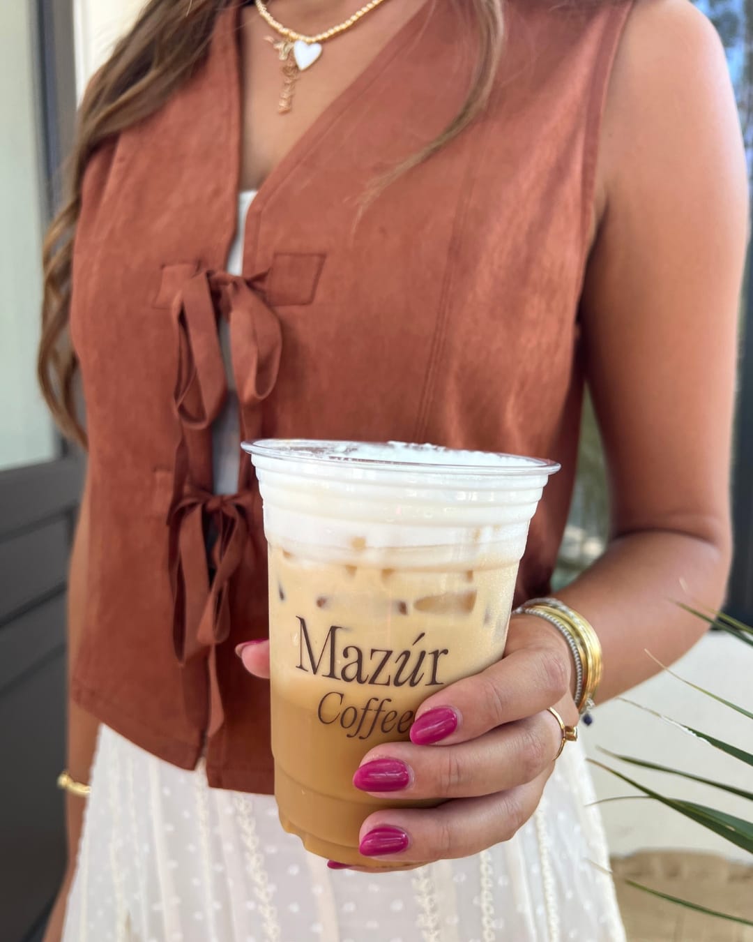 coffee and a burnt orange velvet suede vest showcasing mazur boutique for social media marketing
